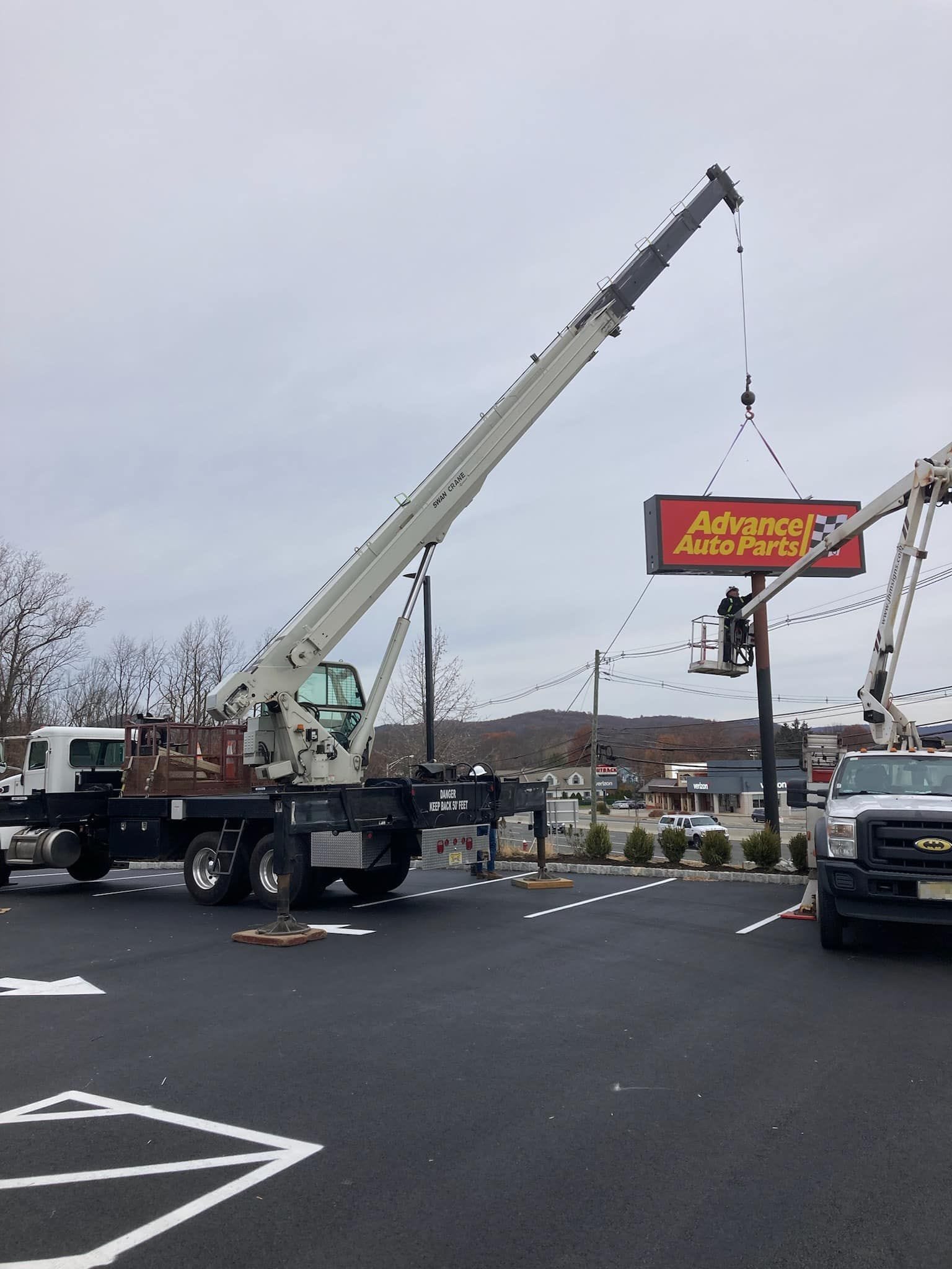 Swan Crane Service installing a retail post sign on-site with National 35-ton swing seat crane with a reach of 165 feet vertical